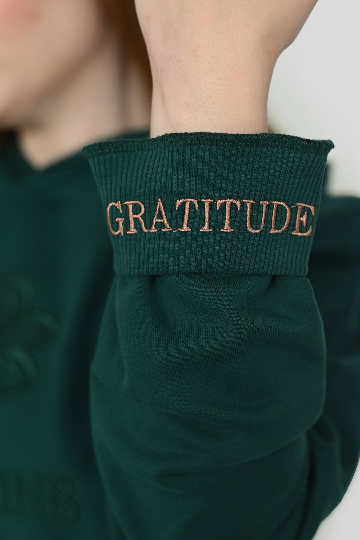 Close-up of the folded cuff of the Gratitude hoodie with the hidden GRATITUDE embroidery