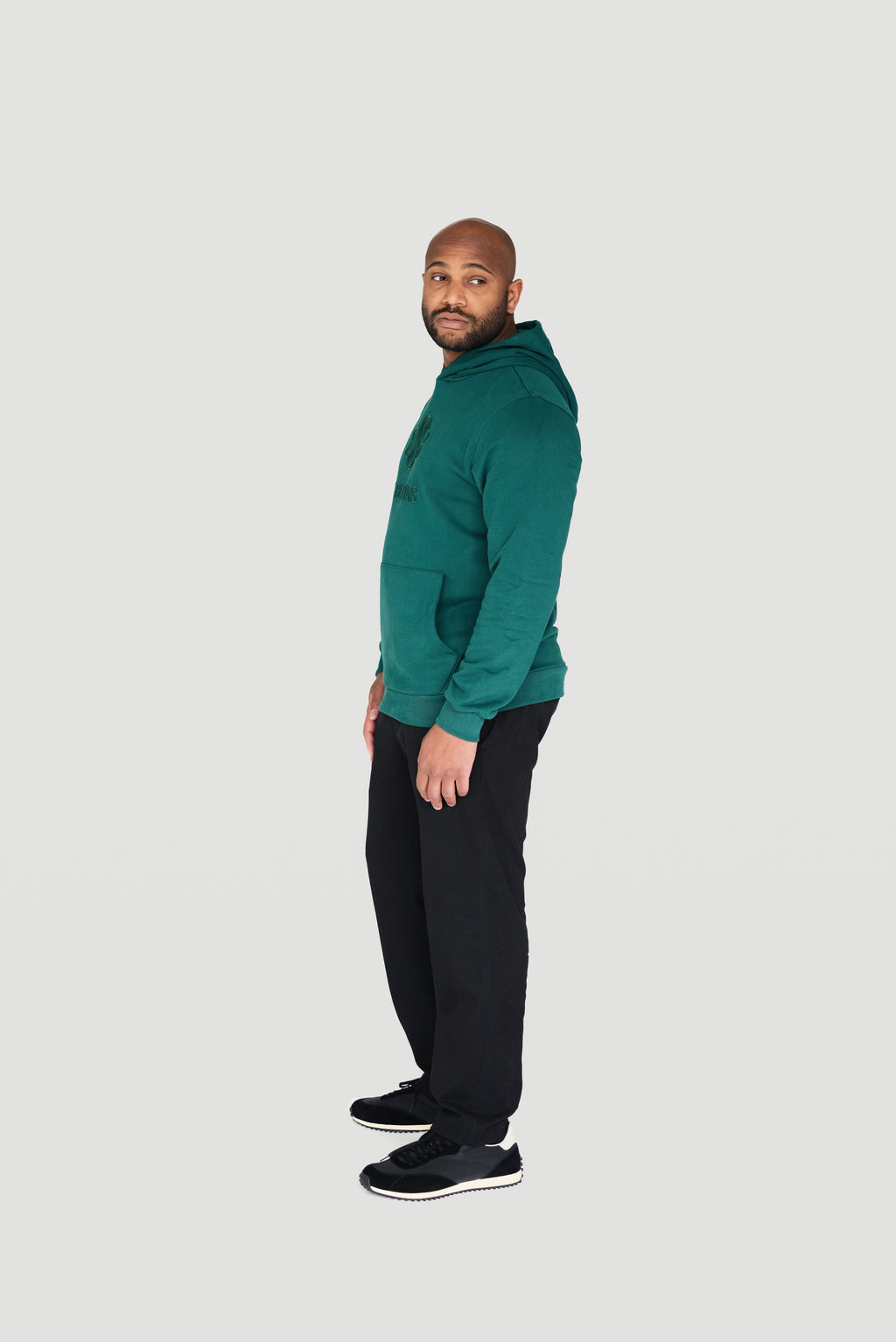 Side view of a man wearing the green Le Butin8 Gratitude hoodie