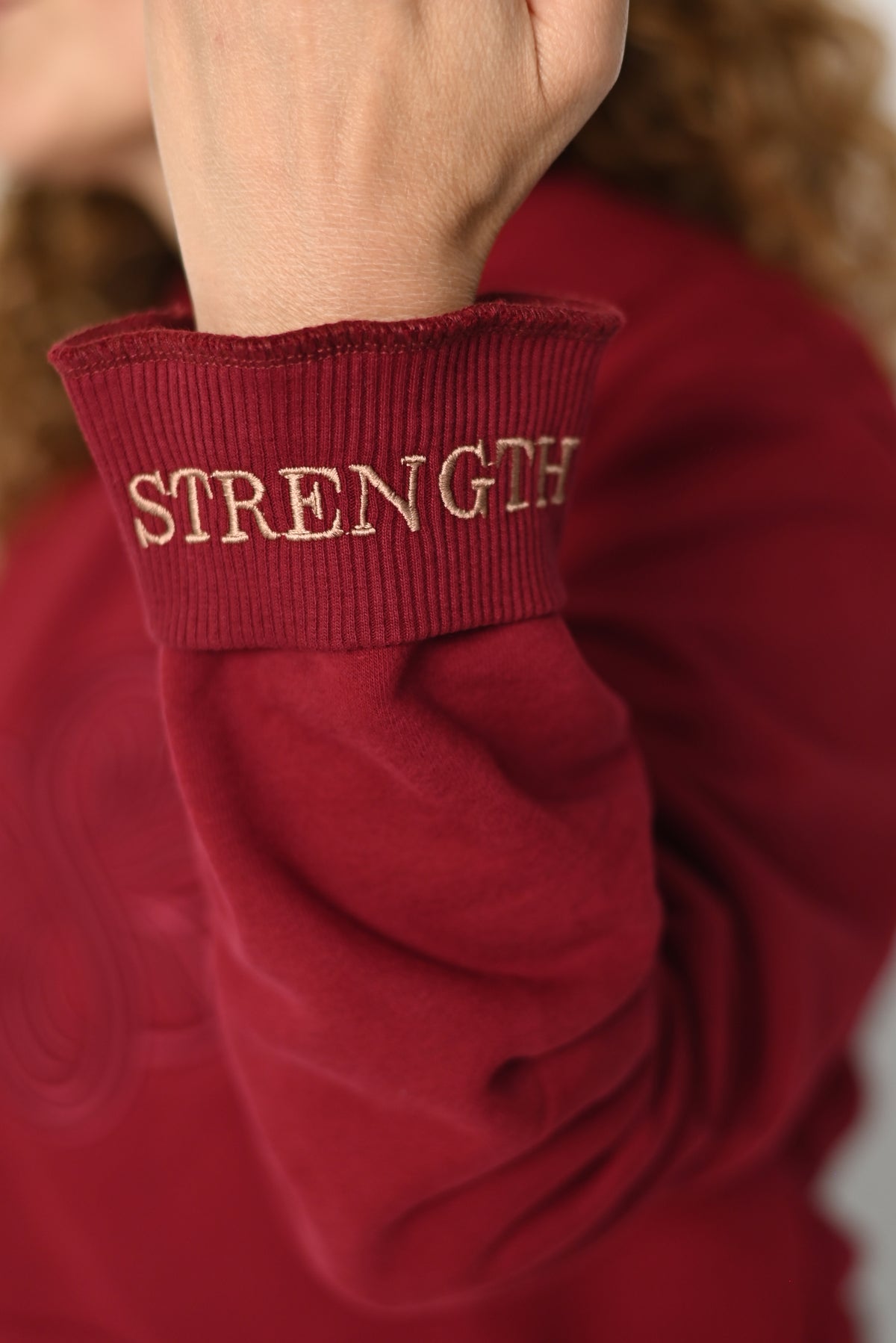 Close-up of the folded cuff of the Strength hoodie with the hidden STRENGTH embroidery
