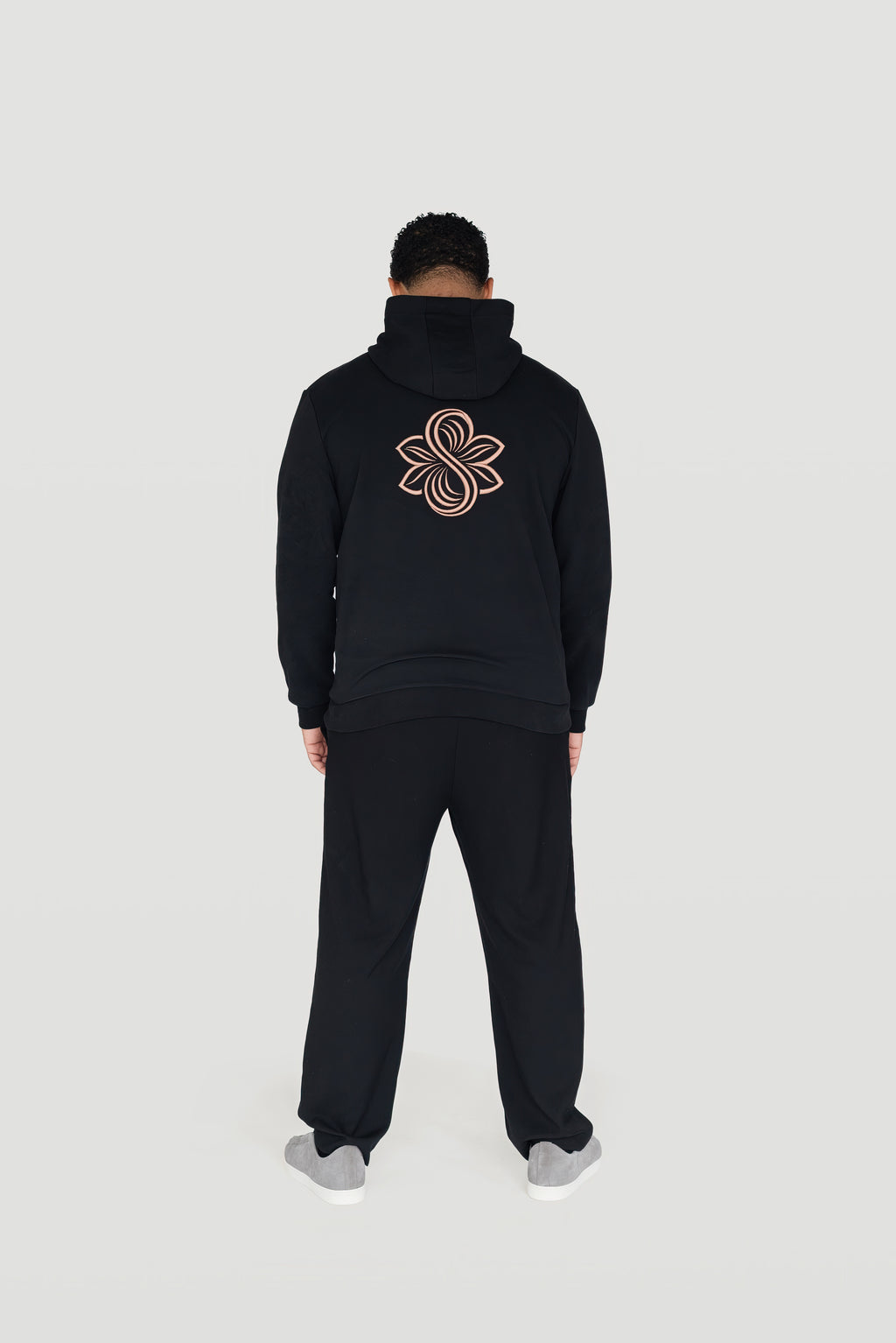 Back view of the black Le Butin8 Believe hoodie showing the signature logo