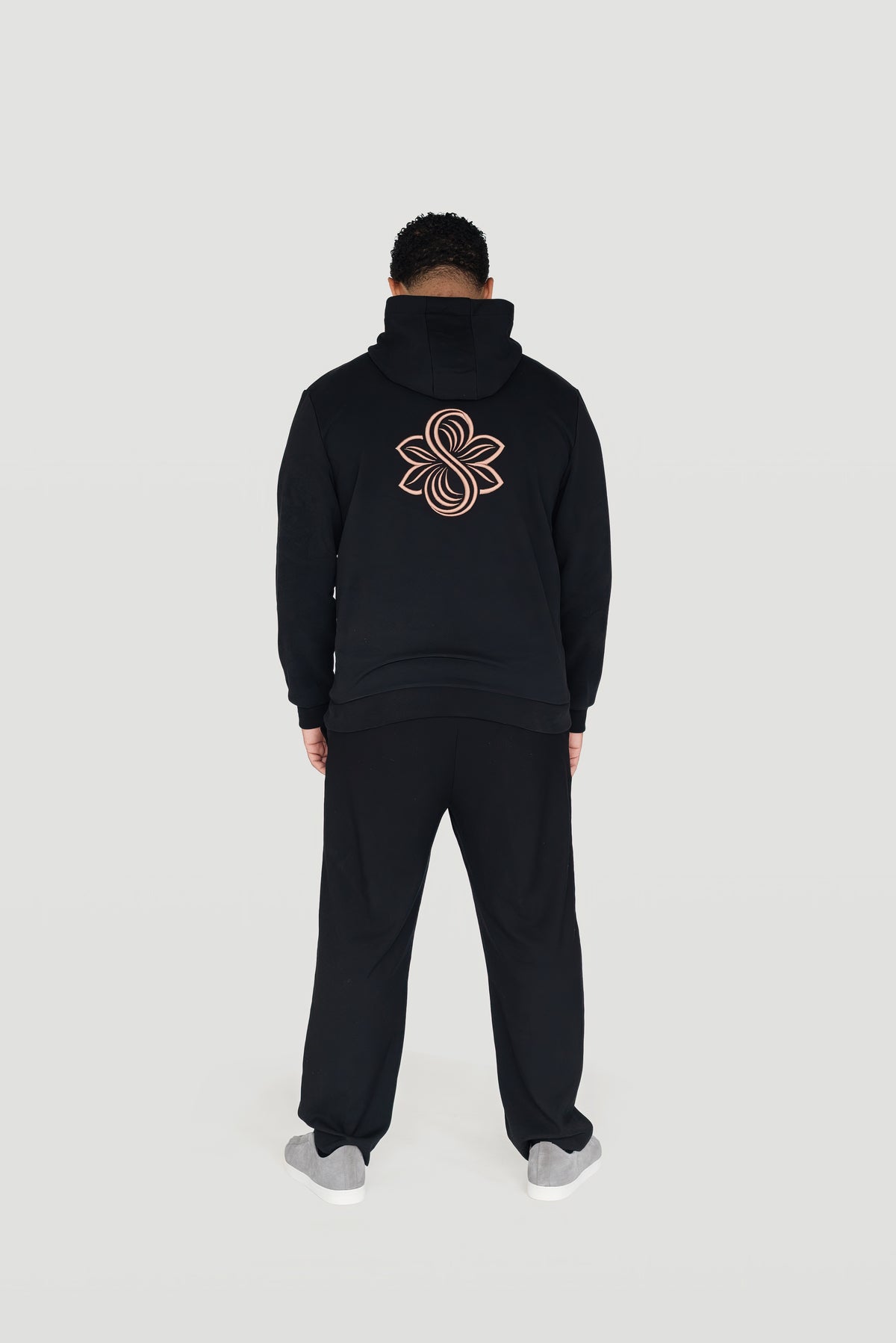 Back view of the black Le Butin8 Believe hoodie showing the signature logo